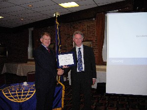 Col. Tom Moncur, British Army (Ret.) (l), presents a certificate of appreciation to May guest speaker Stuart Bennett of QinetiQ.